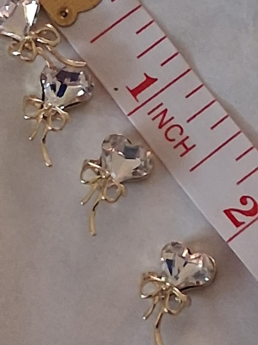 Clear Crystal Heart Drop Nail Art with Gold Bow Accent